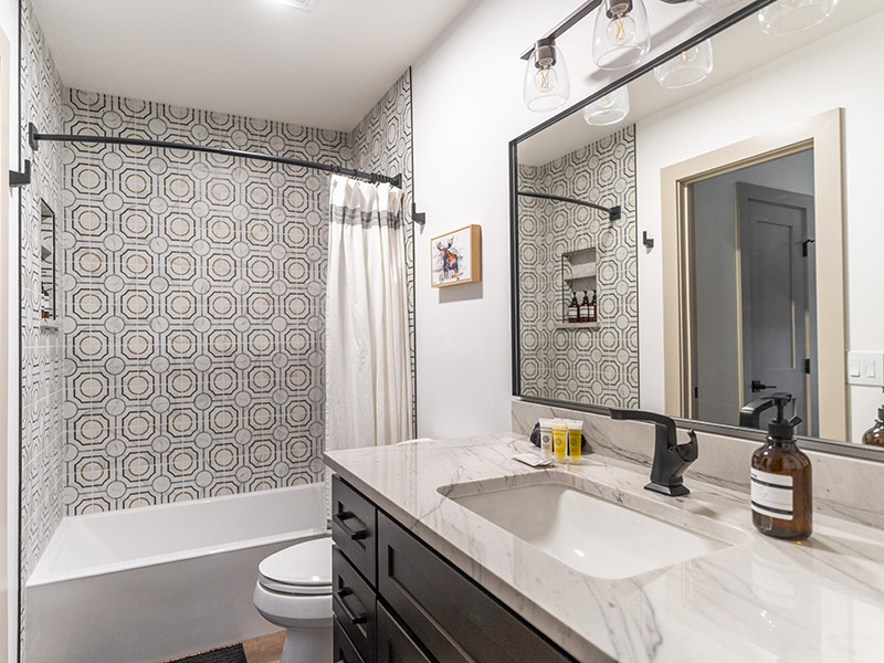 Full Bathroom Remodel Featuring Decorative Porcelain Tile and Custom Vanity with Quartz Top