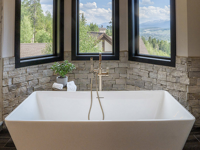 Complete Bathroom Remodel Featuring; Natural Stone Wall, Freestanding Bathtub, Copper Color Faucet with Hand-held Shower Attachment